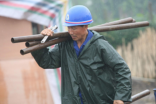 工人冒雨作業(yè)建家園